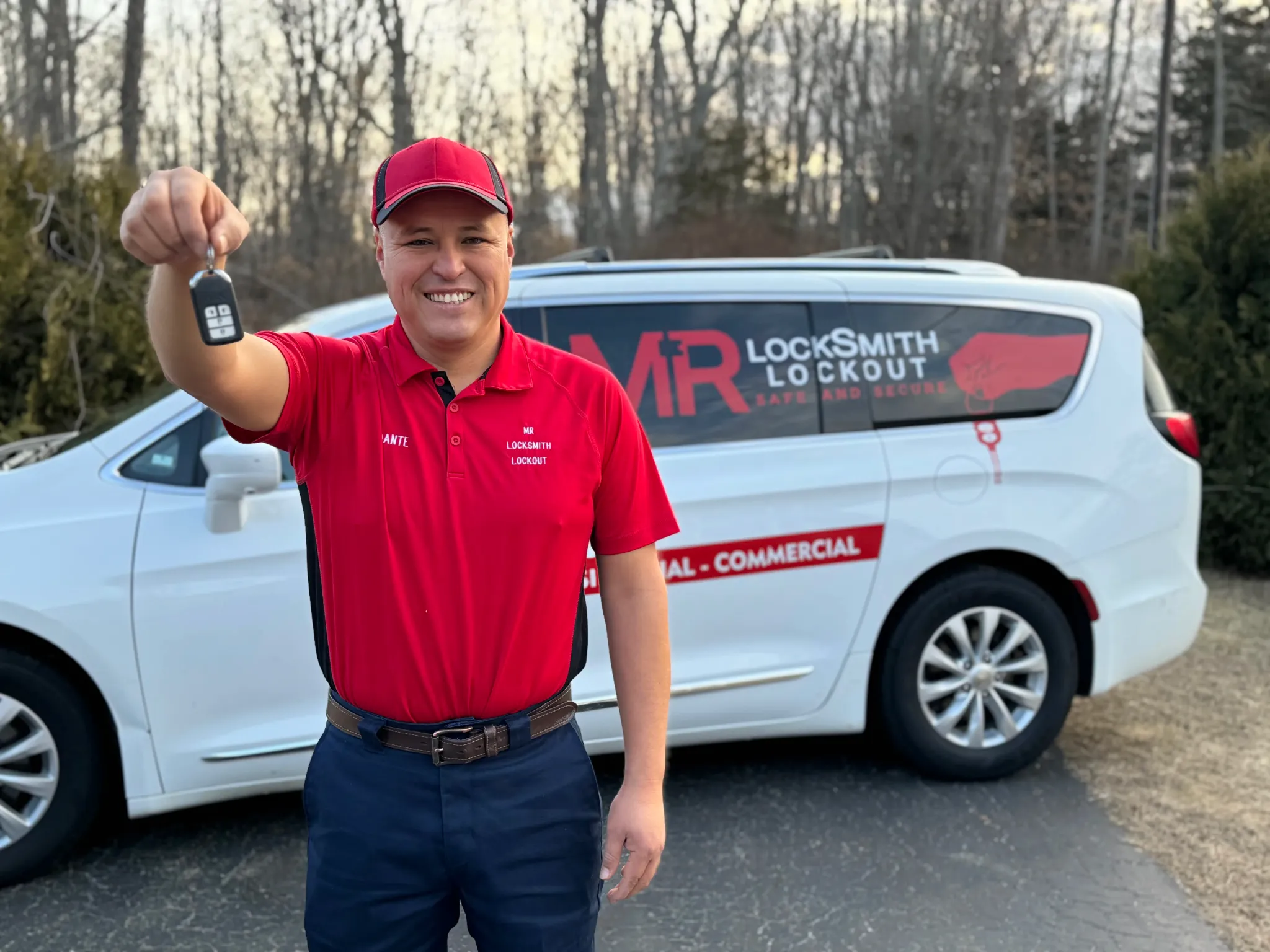 Dante Salcedo holding a programmed car key fob in front of his mobile locksmith service van